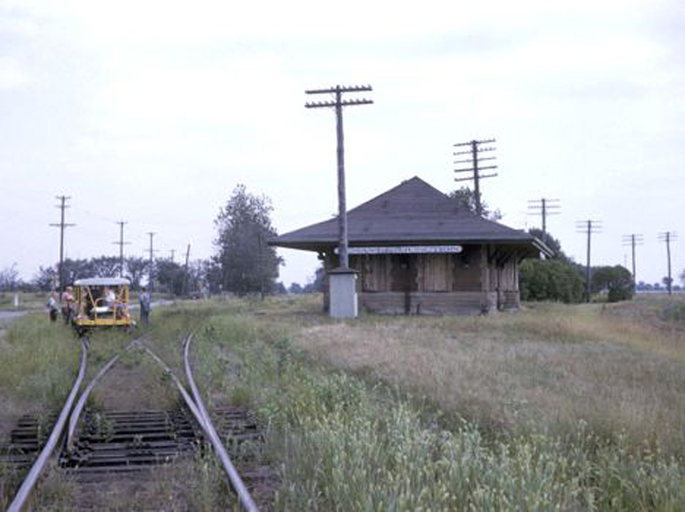 A group of motor cars sits at Lenawee Jct., MI, on the wye connecting the "Old Road" with the Jackson Branch. The depot survived until the mid-1970s; the phone box was later rescued by the Southern Michigan Railroad Society!